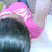 Pixelated image of a figure with pink hair and dark clothing against a light background.