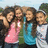 Four girls in casual clothing pose together outdoors with arms around each other, next to text listing names and 'best friends' on a bright pink background.