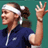 Pixelated static image of a tennis player in profile wearing a headband and dark blue athletic shirt with one arm raised, set against solid teal background.