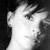 Black-and-white pixelated image of a person's face in profile view, showing ear, eye, nose, and mouth against a dark background.