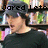 A pixelated image of a person in black clothing and cap with text overlays, set against bookshelves.