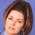 Static pixelated image of a person's face with brown hair against a blue background, rendered in low-resolution 256x256 pixels.