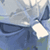 Pixelated static image of a blue and white abstract shape with light gray background, likely representing an anime-style character or object from Disgaea series.