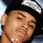 Pixelated image of a person wearing a black cap with a white logo, set against a red background with text elements.