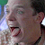 A pixelated close-up of a person's face showing a wide open mouth with tongue extended, eyes partially closed, and visible ear, against a blurred background.
