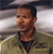 Static pixelated image of a person in military-style clothing with blurred background, likely from a movie or TV show reference.