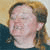 Pixelated static image of a person's face with light brown hair and dark clothing against a gradient background.