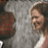 Pixelated static image of a person with light brown hair wearing a white sleeveless top against a gray background.