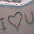 Beach scene with 'I ❤️ U' written in sand, waves receding from the top of each frame.