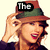 Pixelated image of a person with light brown hair wearing a brown hat with green brim and dark band, hand raised near face, red lips, dark clothing, beige background, text 'The' on black rectangle above hat.