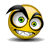 Yellow circular face with green eyes, black eyebrows, and a wide grin showing teeth; small red object near the base of each frame.