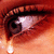 A close-up of a human eye with tears, rendered in pixelated red and orange tones against a gradient background.