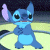 Pixelated blue cartoon character with large black eyes, purple ear, and light blue belly standing against dark and yellow background.