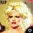 Pixelated static image of a person with blonde hair and red lips, featuring 'RIP' text in the top-left corner.