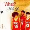 Three basketball players in red jerseys stand against a brick wall with 'What? Let's go...' text and a black heart symbol.