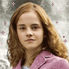 A person with long wavy red hair wearing a pink jacket over a white shirt, with pink and purple star-like shapes floating around them against a blurred background.