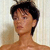 Pixelated image of a person with short dark hair, light skin, and a neutral expression, cropped at the shoulders against a light background.