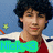 Pixelated image of a person with dark curly hair wearing red clothing, standing against a blue background with white and green elements.