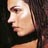 Pixelated close-up of a person's face in profile view with visible facial features and dark hair against a dark background.