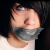 A close-up of a person with dark hair and blue eyes, wearing a white shirt and having gray tape over their mouth.