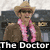 A pixelated figure in a brown coat, pink lei, and straw hat with text 'The Doctor' below.