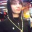 A pixelated static image shows a person with light skin and dark hair wearing a dark jacket over a light shirt, holding a yellow object near their face.