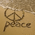A beach scene with a peace symbol drawn in sand, waves at top; yellow text 'Ad' on black background; heart shape in sand with red 'Love' text below.