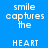 Blue background with white pixelated text 'smile captures the HEART' repeated in a , some text sections overlaid by pink rectangular blocks