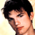 Static pixelated close-up of a person's face with dark hair and light skin against a pale yellow background.