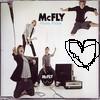 Static image of four people in dynamic poses with 'McFLY' text and a pixelated heart symbol on a light background.
