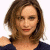 A pixelated image of a person with shoulder-length brown hair wearing a dark blue top, next to green text on a dark background.