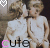 Two children in white dresses sit side-by-side, one kissing the other's cheek; a pink heart icon appears above them. The word 'cute' is displayed below with varying letter colors.