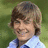 A split-screen image with a pixelated photo of a smiling person on the top-left and green text on blue and gray backgrounds.