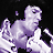 Pixelated static icon of a stylized purple figure with white highlights against black background, featuring rounded head, simplified body, and flowing tail-like appendage.