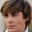 Pixelated close-up of a person's face with brown hair, light skin, and a neutral expression, cropped to show only the head and shoulders.