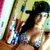 A woman in a bikini top and dark hat poses against a striped background with blue accents, her head turning from left to right across frames.