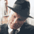 Static 48x48 pixel icon showing a person in dark clothing and hat with light skin, partially cropped on the left side against a white background.