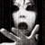 Black-and-white animated icon shows a person with dark hair and heavy eye makeup, mouth open in shock or fear, hands raised near face against dark background.