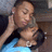 Two people in close physical contact, one wearing a light blue top and the other with dark hair resting their head on the first person's shoulder.