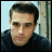 A 48x48 pixel animated contact sheet showing two sequential frames of a person with short dark hair wearing a dark shirt against a light blue background with vertical green and brown elements.