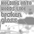 A static image of repeated text 'HOLDING ONTO WORDS LIKE BROKEN GLASS' in gray sans-serif font over a light background with faint abstract shapes.