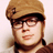 Static pixelated image of a person wearing a brown cap and glasses with visible facial features including eyes, nose, mouth, and hair.