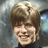 A pixelated image of a smiling person with light brown hair on the top-left, next to blue with green text reading SMILE! and YOU'RE DAVID BOWIE!!