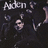 Pixelated image with dark background showing partial text 'Aiden' and abstract shapes resembling a face and limbs.