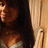 Pixelated image of a person with dark hair and light skin, wearing a brown top against a beige background.