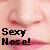 Pixelated image with pink and beige background showing partial face, dark text reading 'Sexy Nose!' in two lines.