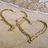 Two interlocking heart shapes drawn in light-colored sand on a textured background with red text overlays.