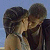 Static 50x50 pixel icon showing two figures in close embrace against a light blue background, with visible facial features and clothing details.