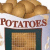 A static pixelated image shows a white banner with red text reading "POTATOES" above a dark green door frame and brown textured background.