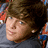 Pixelated image of a person with brown hair and light eyes, next to green pixelated text on a black background.